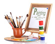 Photo: Small easel with sheet of paper and art supplies isolated Small easel with sheet of paper and art supplies isolated
