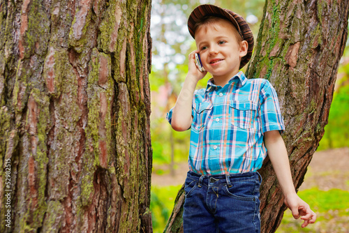 Photo: Young boy talking on mobile phone Young boy talking on mobile phone
