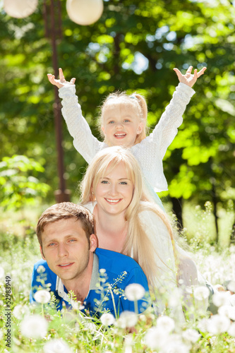 Photo: Happy mother, father and daughter in the park Happy mother, father and daughter in the park