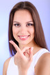 Young woman putting contact lens in her eye close up