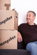 Man sitting on the sofa next to his moving boxes