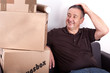 Man sitting on the sofa next to his moving boxes