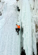 Ice climber struggles up a frozen waterfall.