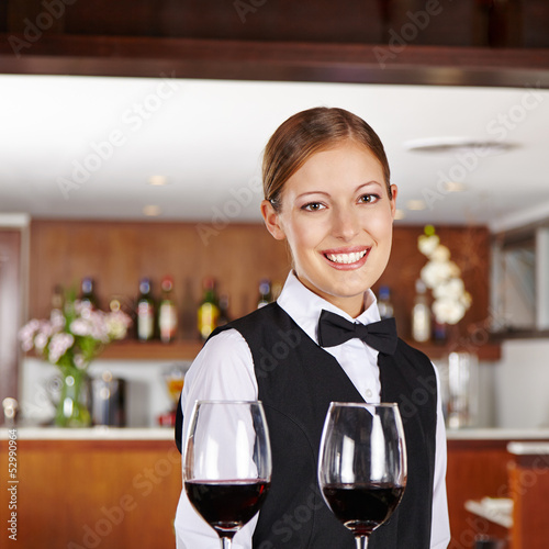 Photo: Kellnerin serviert Rotwein im Restaurant Kellnerin serviert Rotwein im Restaurant