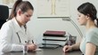 Female doctor writing rx prescription for patient