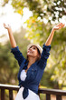 young woman outdoors with arms outstretched
