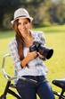 happy young woman holding camera outdoors
