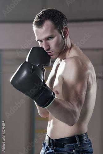 Photo: Waist-up of young male boxer in gym Waist-up of young male boxer in gym