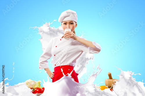 Photo: Asian female cook against milk splashes Asian female cook against milk splashes