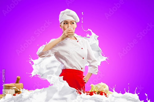 Photo: Asian female cook against milk splashes Asian female cook against milk splashes