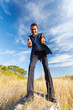 businessman on top of rock giving thumbs up