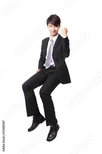 Photo: Successful business man sitting on something Successful business man sitting on something