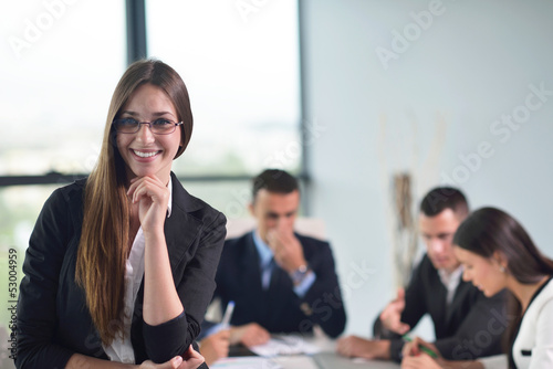 Photo: business woman with her staff in background at office business woman with her staff in background at office