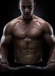 Close up of young muscular man lifting weights