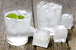 Glass of water with ice cubes on vintage wooden planks