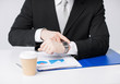 Photo: businessman with graphs pointing at watch businessman with graphs pointing at watch