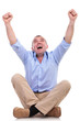 casual middle aged man sits and cheers
