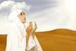Photo : Asian female muslim in white praying at desert Asian female muslim in white praying at desert