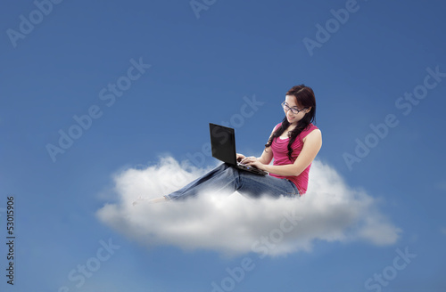 Photo: Attractive female using laptop on cloud Attractive female using laptop on cloud