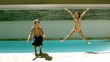 Siblings jumping together in the swimming pool