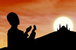 Card design silhouette of muslim man praying at sunset