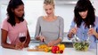 Attractive friends preparing salad in the kitchen