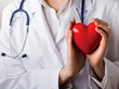 Female doctor with stethoscope holding heart