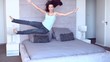 Pretty woman leaping onto bed