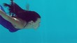 Vídeo: Brunette woman swimming underwater in blue bathing suit Brunette woman swimming underwater in blue bathing suit