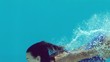 Woman in blue swimsuit swimming underwater