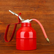 Oil can on wooden background