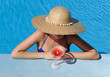 Woman at poolside with cosmopolitan cocktail