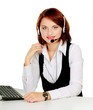 Photo: A young customer service girl with a headset at her workplace A young customer service girl with a headset at her workplace