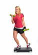 Frau auf Fitnessboard mit Hanteln