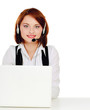Photo: A young customer service girl with a headset at her workplace A young customer service girl with a headset at her workplace