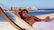 Man relaxing in a hammock on the beach