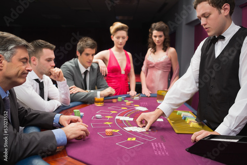 Photo: People looking at dealer dealing blackjack cards People looking at dealer dealing blackjack cards