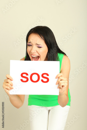 Photo: Girl showing stop sign on grey background Girl showing stop sign on grey background