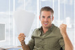 Foto: Cheerful creative business employee raising his arms Cheerful creative business employee raising his arms