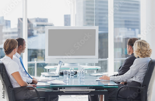 Photo: Business people looking at a screen Business people looking at a screen