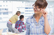 Portrait of a cheerful designer holding her reading glasses