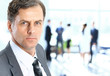 Business man at the office with a group behind him