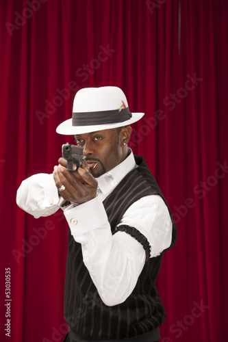 Photo: African American male in retro mobster suit holding a gun African American male in retro mobster suit holding a gun