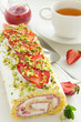 Strawberry roll with cream and pistachios.
