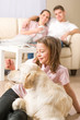 Playful girl petting family dog with parents