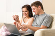 Photo: Cheerful couple using laptop together Cheerful couple using laptop together