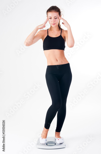 Photo: happy young woman on weight scales happy young woman on weight scales