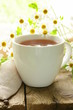 Photo: cup of tea and chamomile flowers on a wooden table cup of tea and chamomile flowers on a wooden table