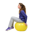 Girl doing exersises on the yellow ball