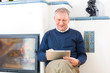 Photo: Senior at home in front of fireplace Senior at home in front of fireplace